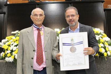 O presidente do Sindjor-MT, Itamar Perenha, recebe comenda das mãos do deputado Paulo Araújo. 